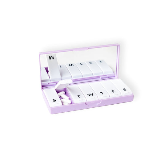 Lilac pill organizer box with open lettered compartments and small tablets