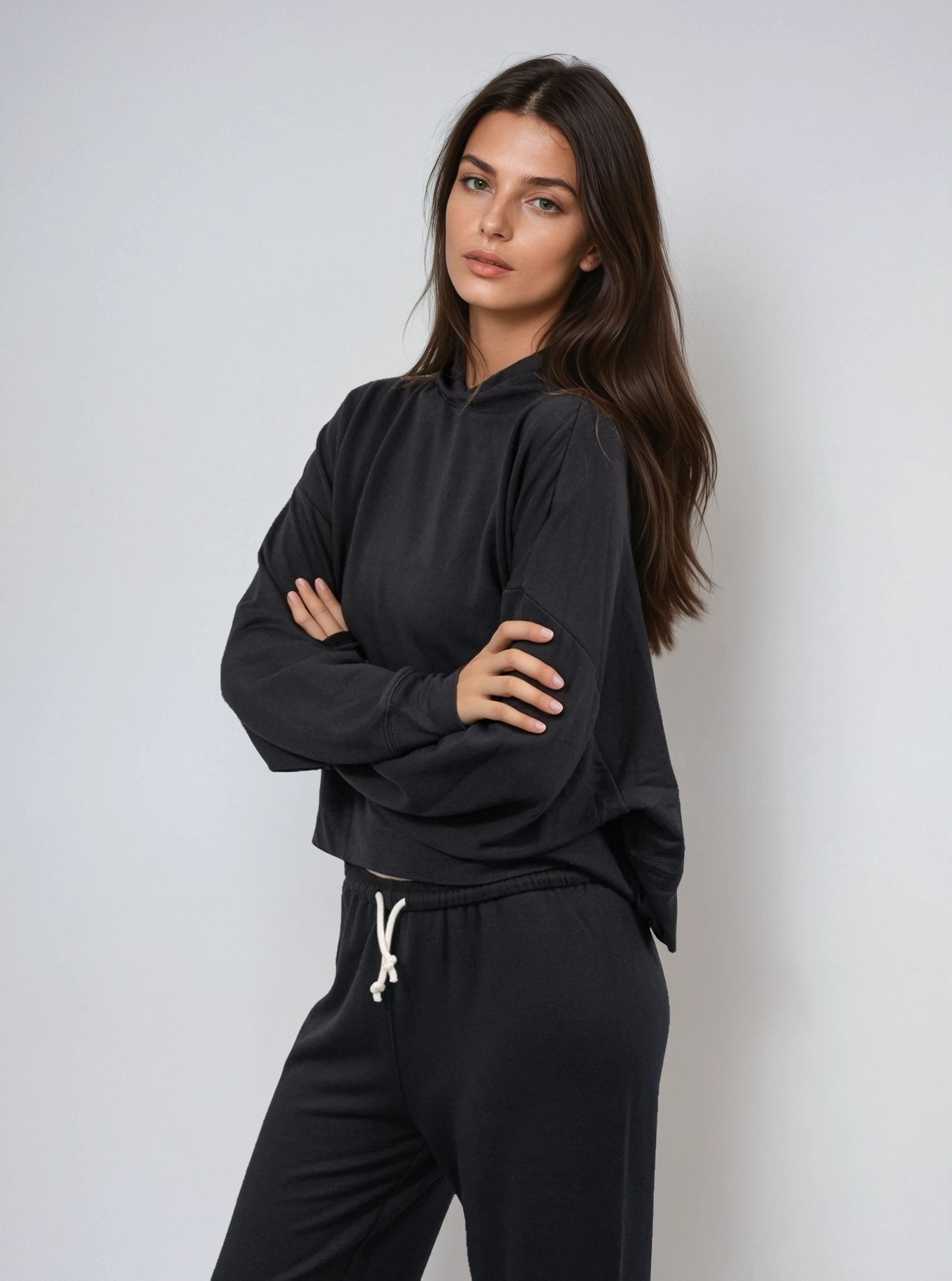 Black cropped pullover hoodie with hood and kangaroo pocket, side front view