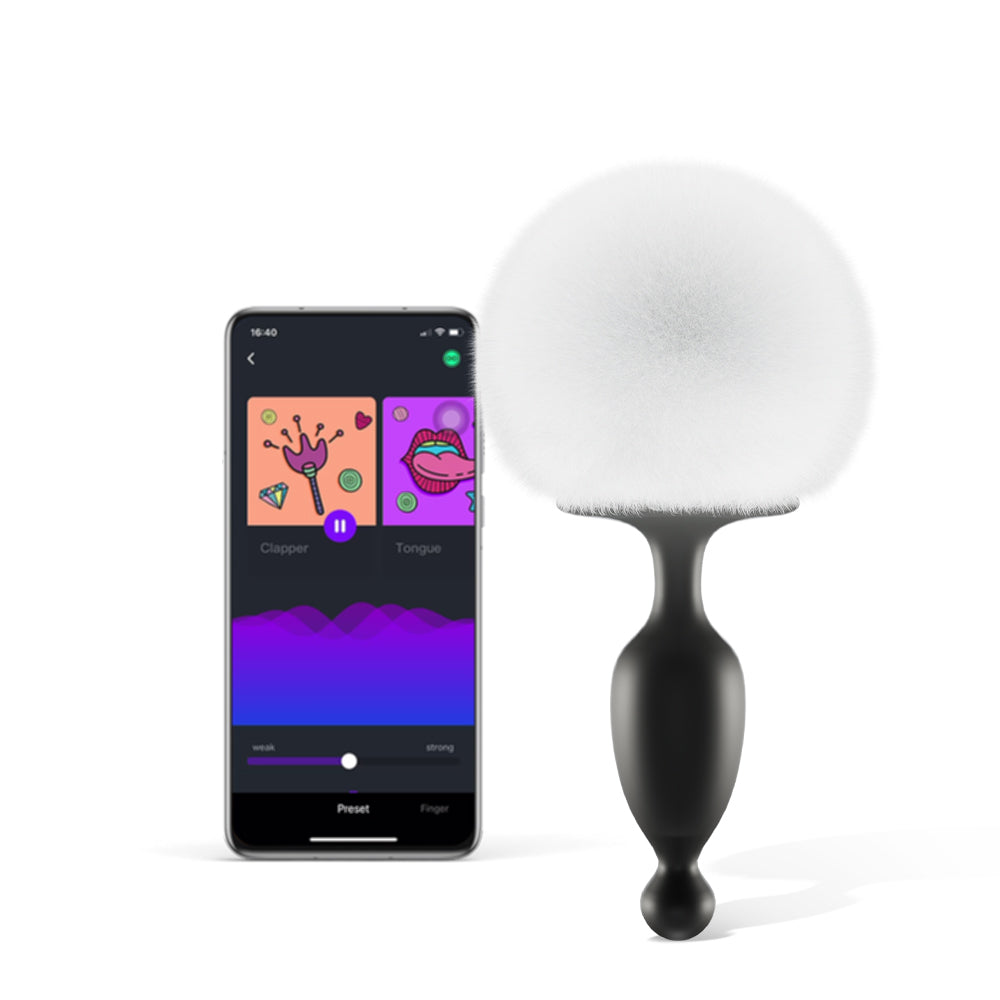 App-controlled bunny tail massager with black silicone body and white fuzzy pom