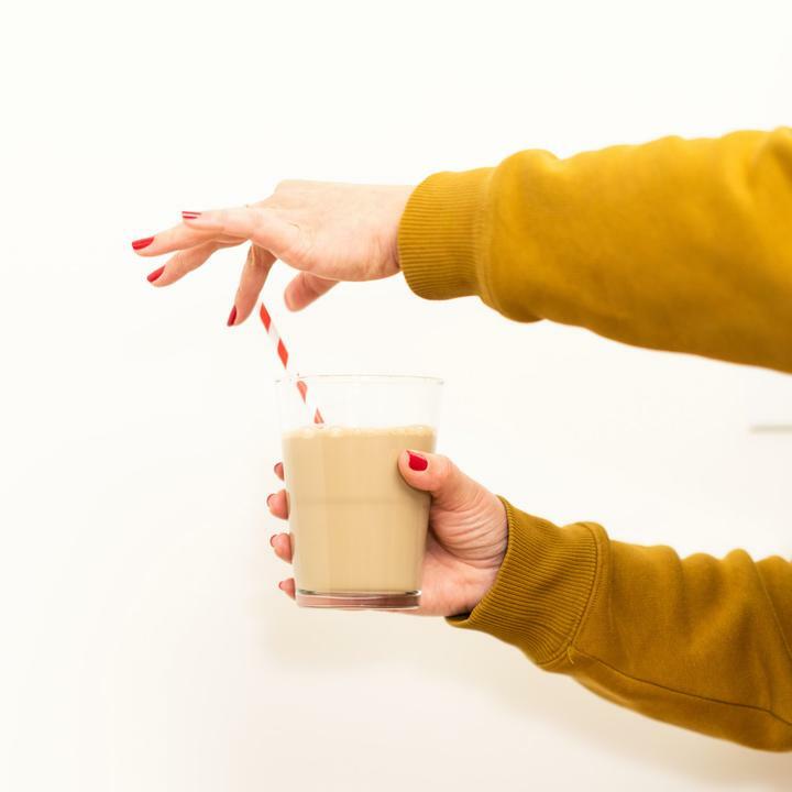 Petrolatum dressing in a small cup for application, held by hands