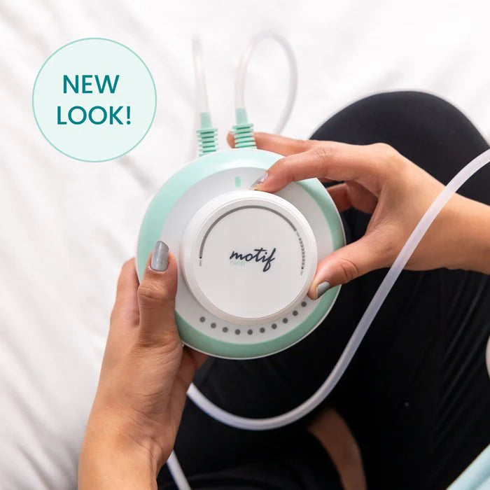 Motif twist double electric breast pump controller in hands with attached tubing