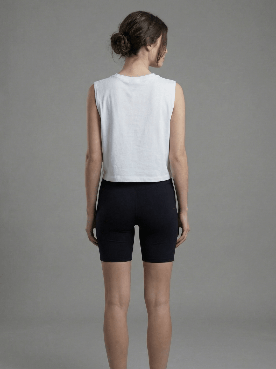 White muscle tank shown from the back, sleeveless with crew neckline