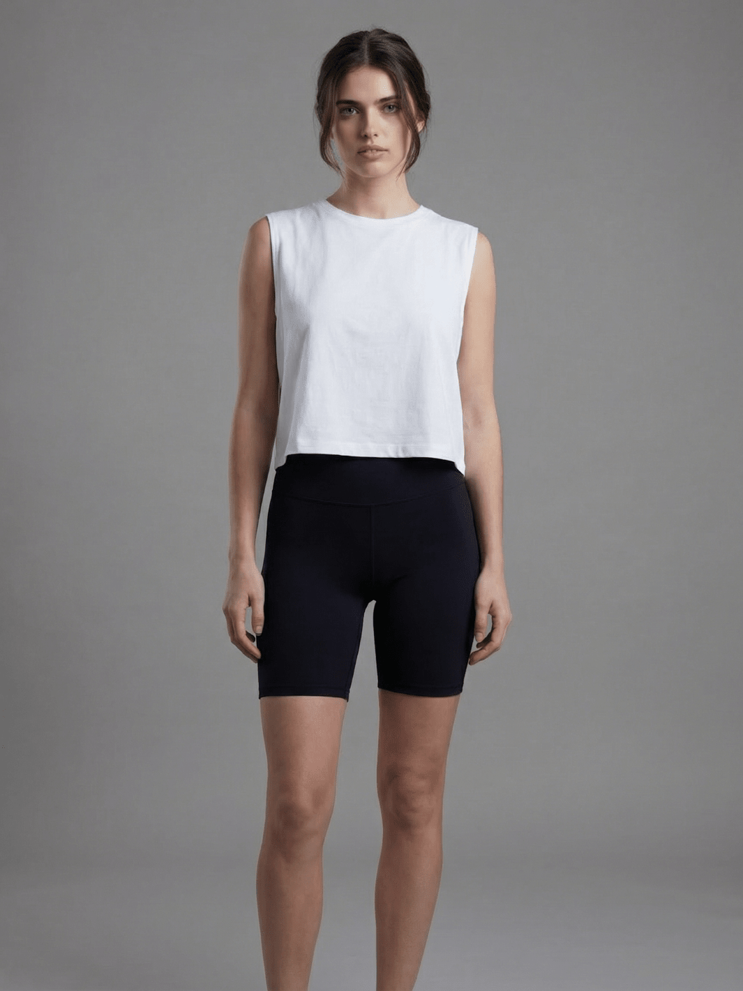 White sleeveless muscle tank with crew neck, slightly cropped hem