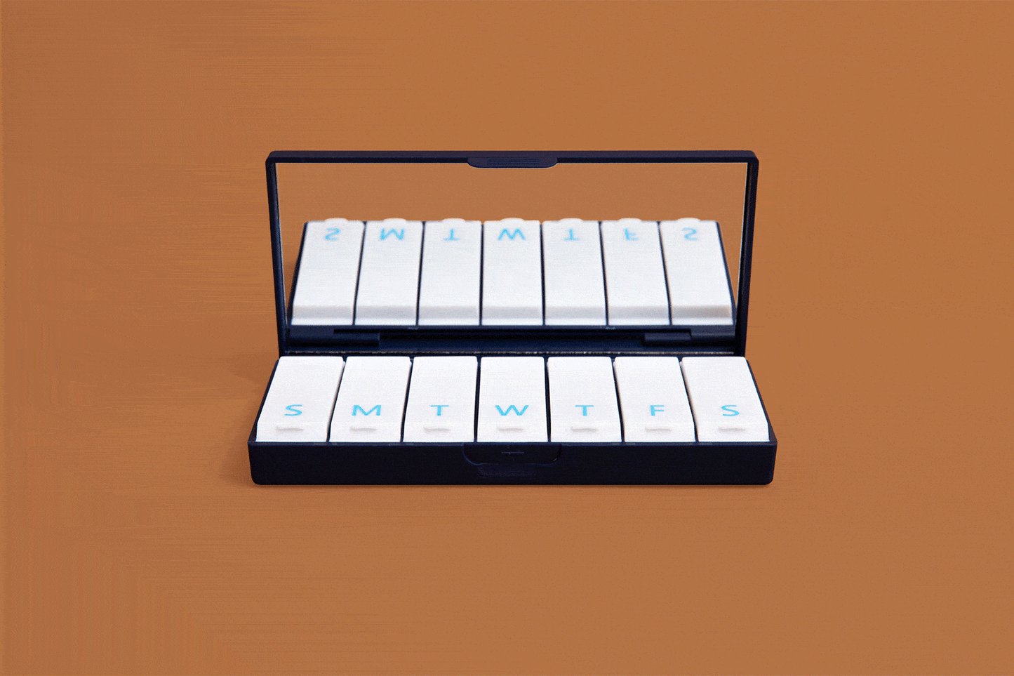 Navy blue pill box open with white labeled day slots