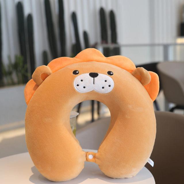 Orange U-shaped lion neck pillow with white muzzle and stitched nose