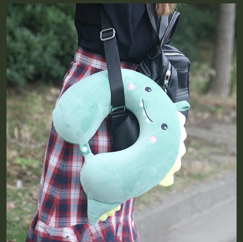 Light blue U-shaped animal neck pillow with stitched face, carried by a child
