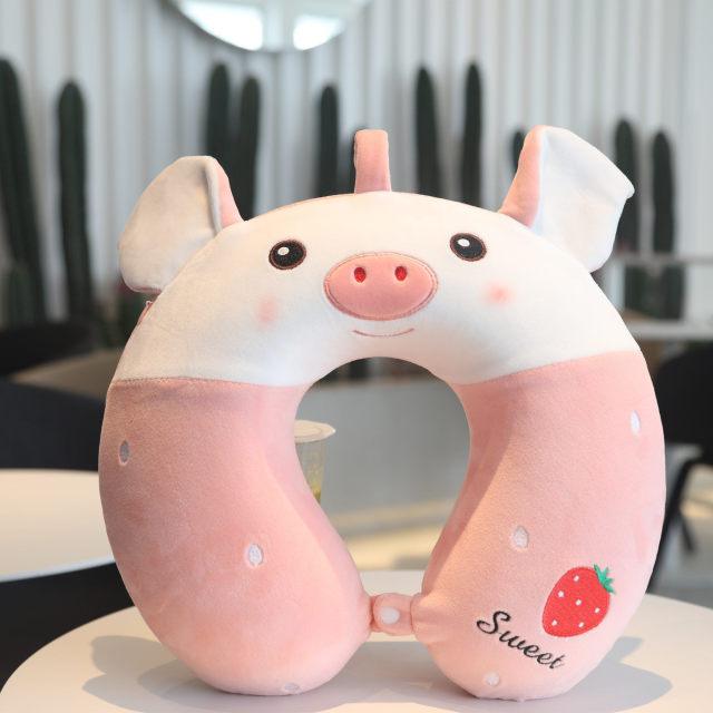 Cream and pink pig U-shaped neck pillow with smiling face and rosy cheeks