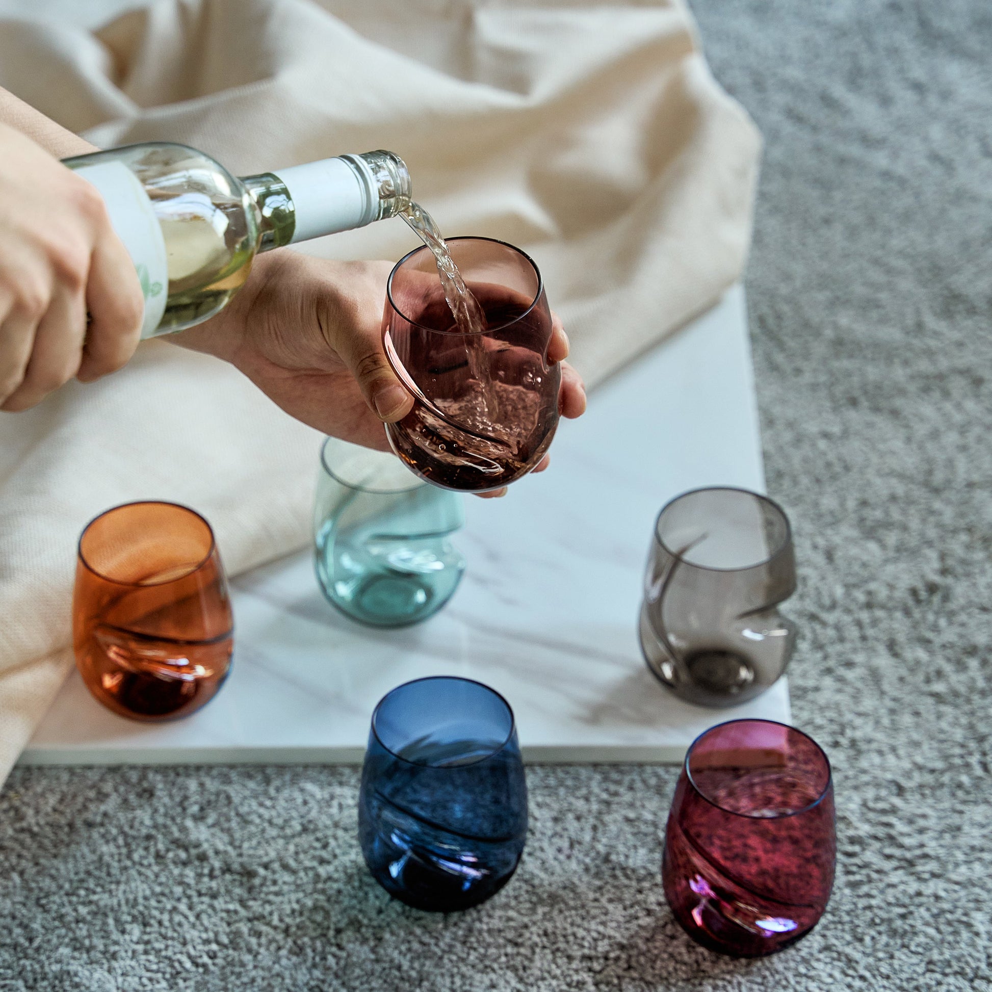 Set of 6 acrylic stemless wine glasses, finger-indented bowls, with one being filled