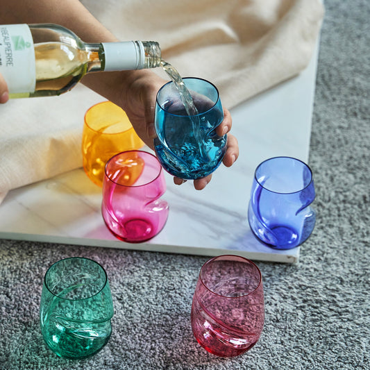 Stemless acrylic wine glass with finger-indent, blue, being filled; set of 6