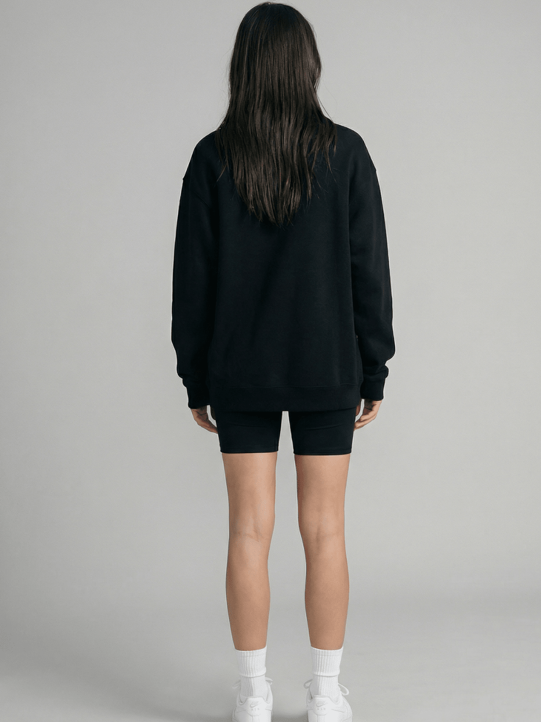 Back view of dark crewneck sweatshirt with full-length sleeves and hem ribbing