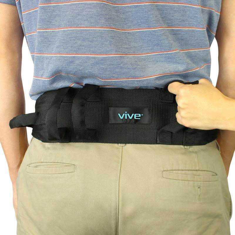 Black padded transfer gait belt fastened at waist, caregiver hand adjusting clasp