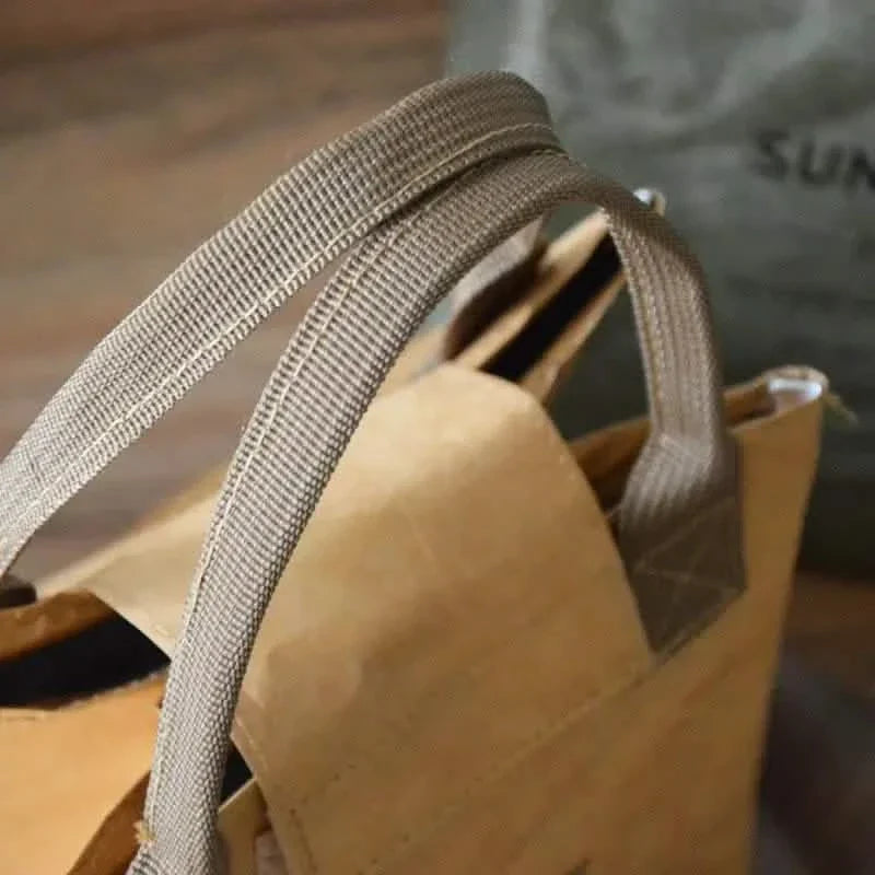 Brown insulated paper bento bag with woven carry strap and folded top handle