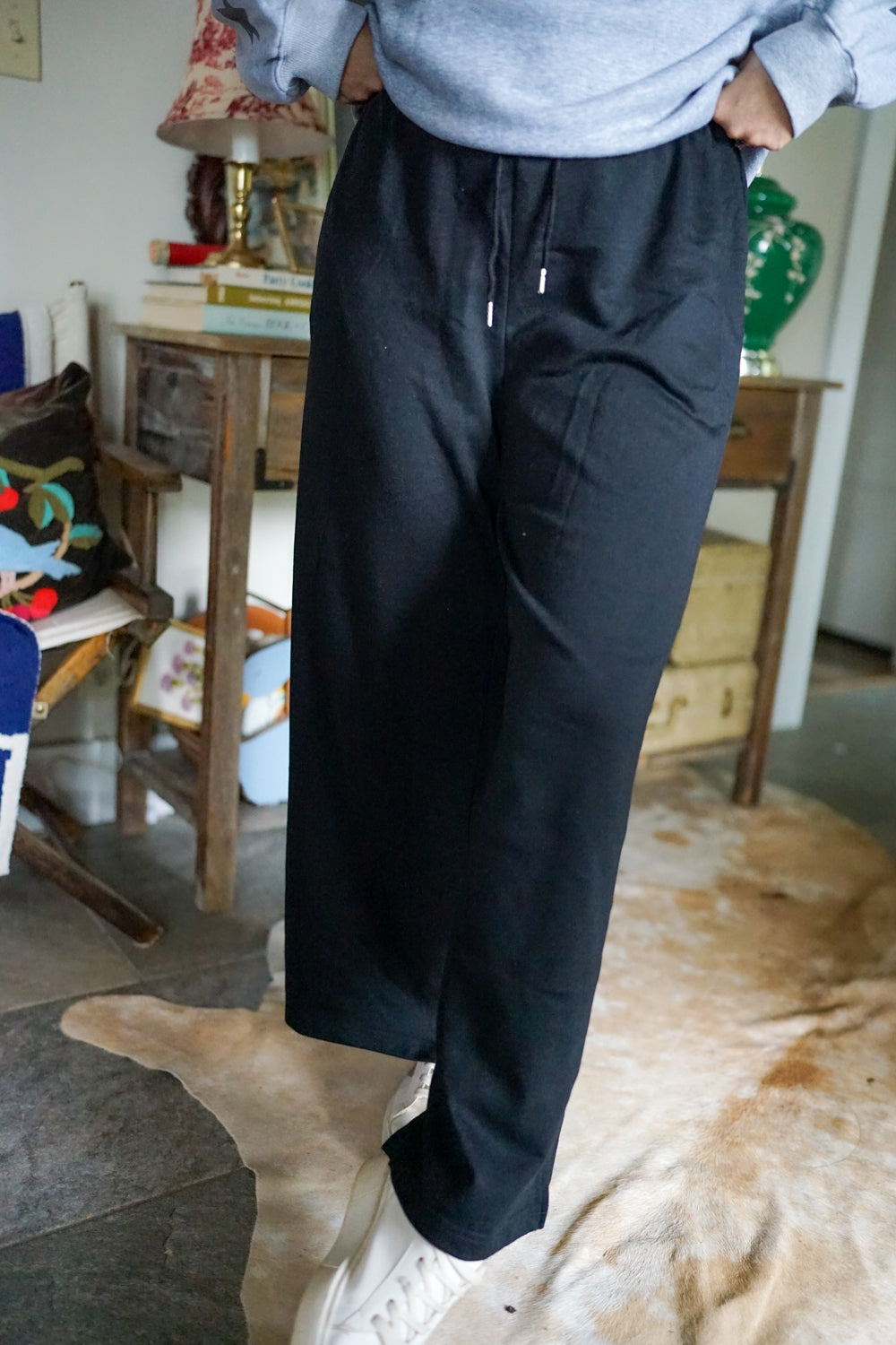 Black drawstring sweatpants with elastic waist and relaxed tapered legs, front view