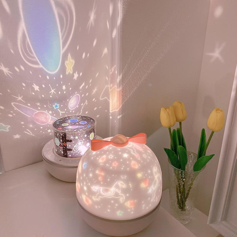 Rotating LED night light projector with pink-tinted dome glow and white base