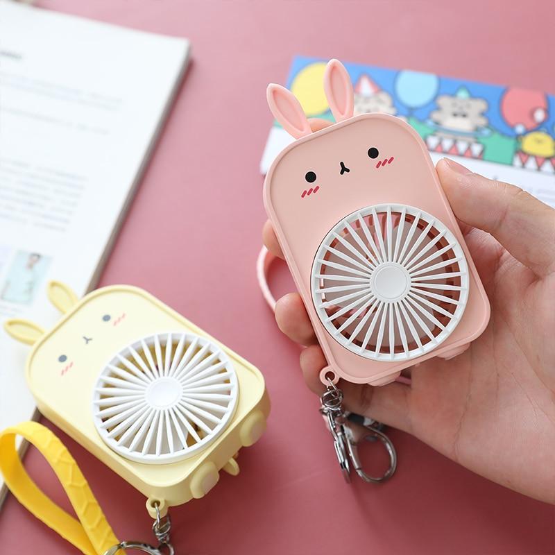 Pink bunny pocket fan with keychain clip, held in hand