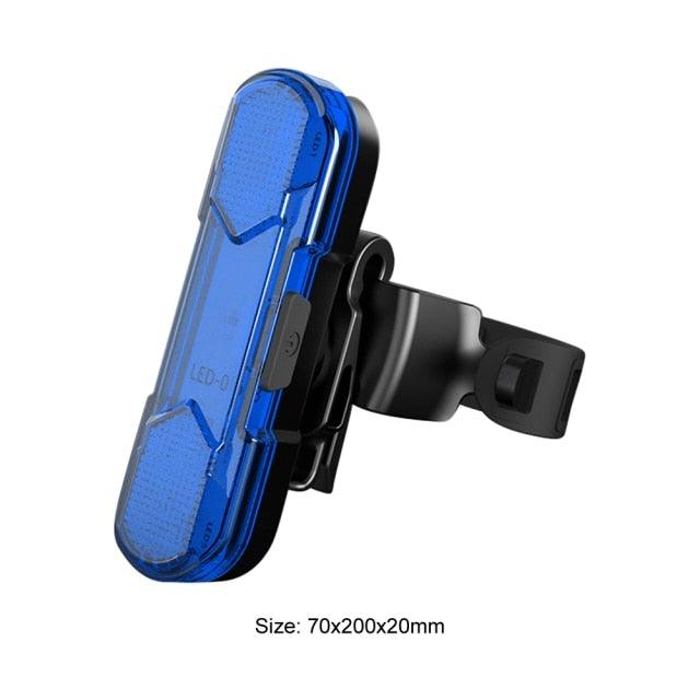 Mini bicycle headlight with blue-tinted clear lens and black silicone mount