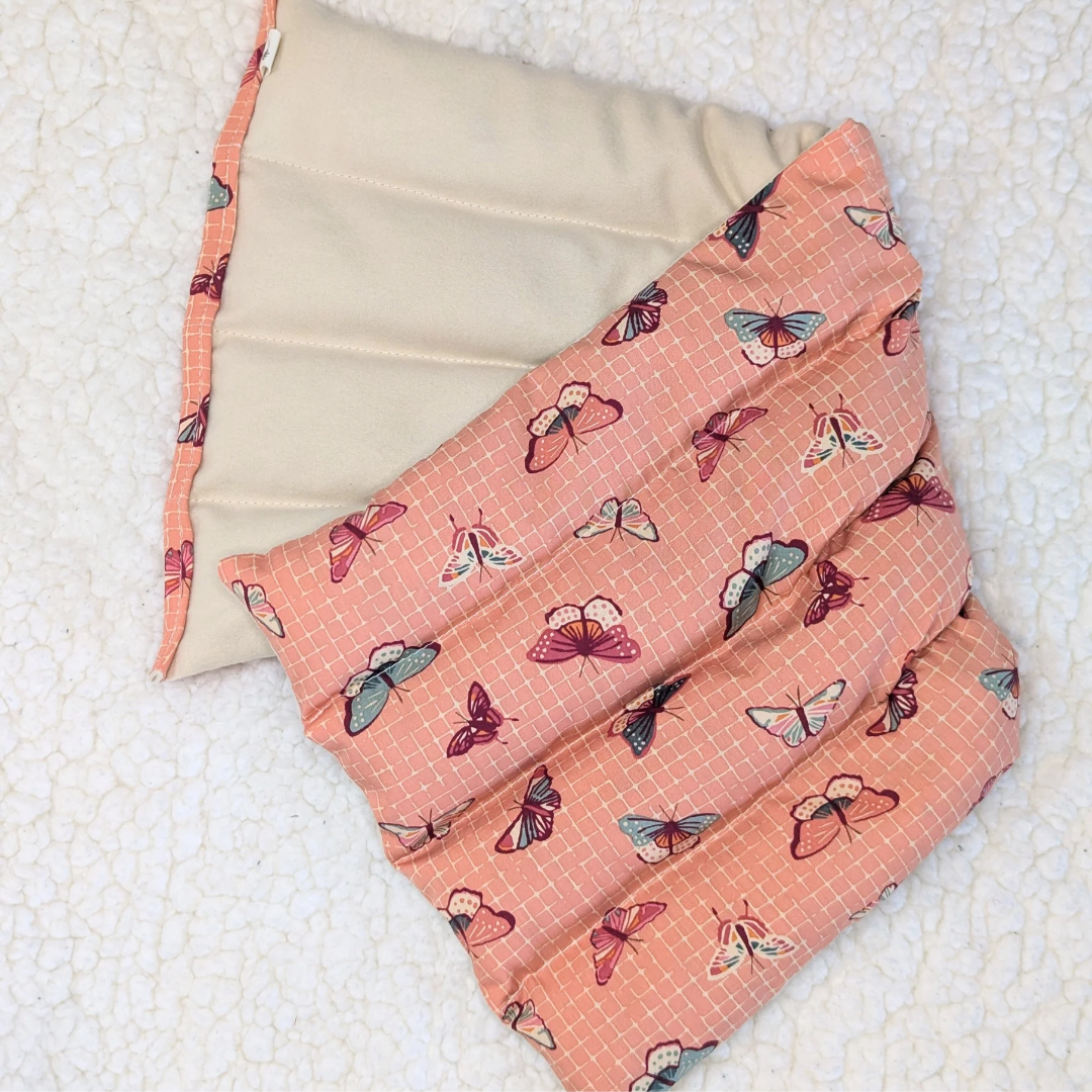 Weighted heating pad with coral butterfly lattice front, folded corner with visible seams