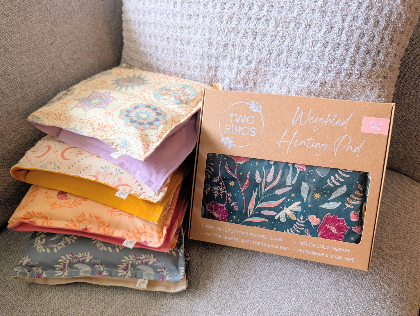Scent-free weighted heating pad gift box next to stacked floral cotton flannel pads