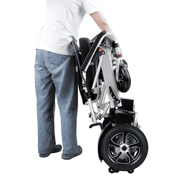Folded electric wheelchair, grey frame, large rear wheels and control panel visible