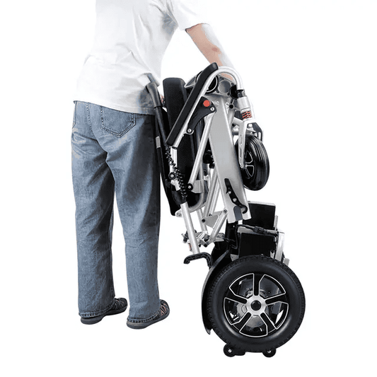 Folded electric wheelchair, grey frame, large rear wheels and control panel visible
