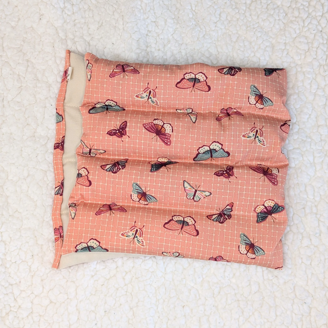 Weighted heating pad with fluttering lattice butterfly print, coral flannel cover