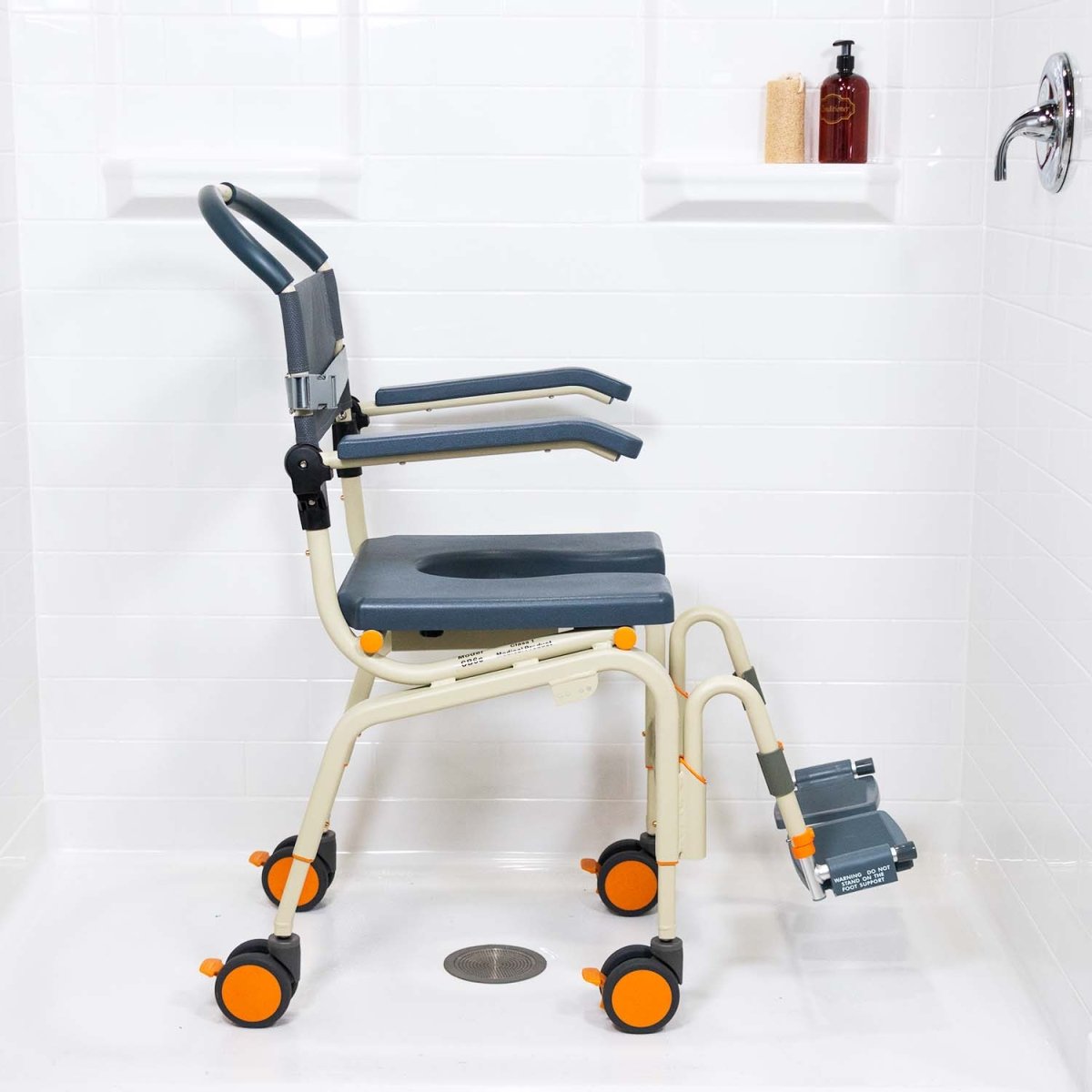 Roll-in shower chair with removable footrest and blue upholstery, wheeled base