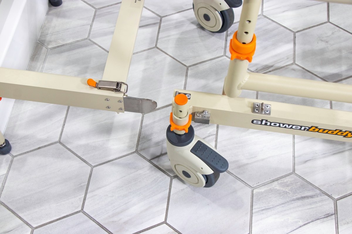 Rolling shower chair frame with wheels, orange grips, and adjustable foot support