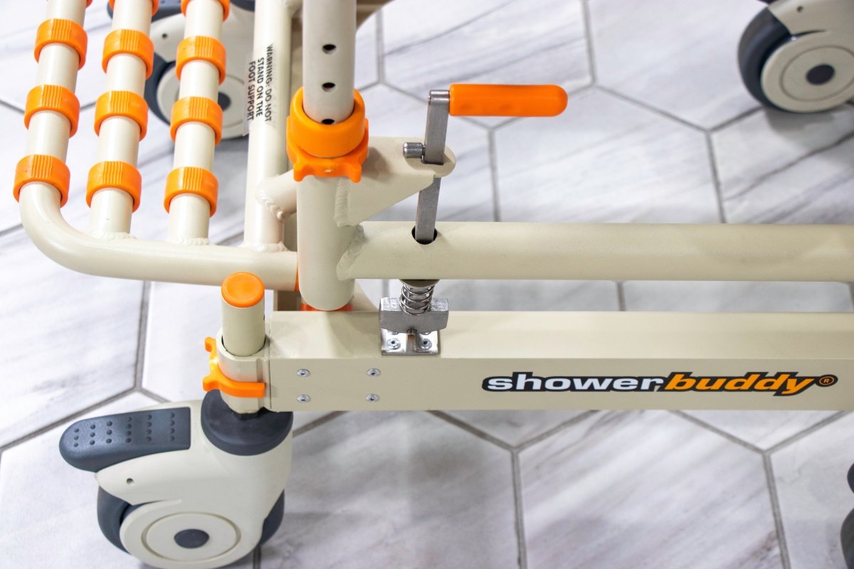 Shower chair arm rail with suction-style grips and textured footplate, orange controls