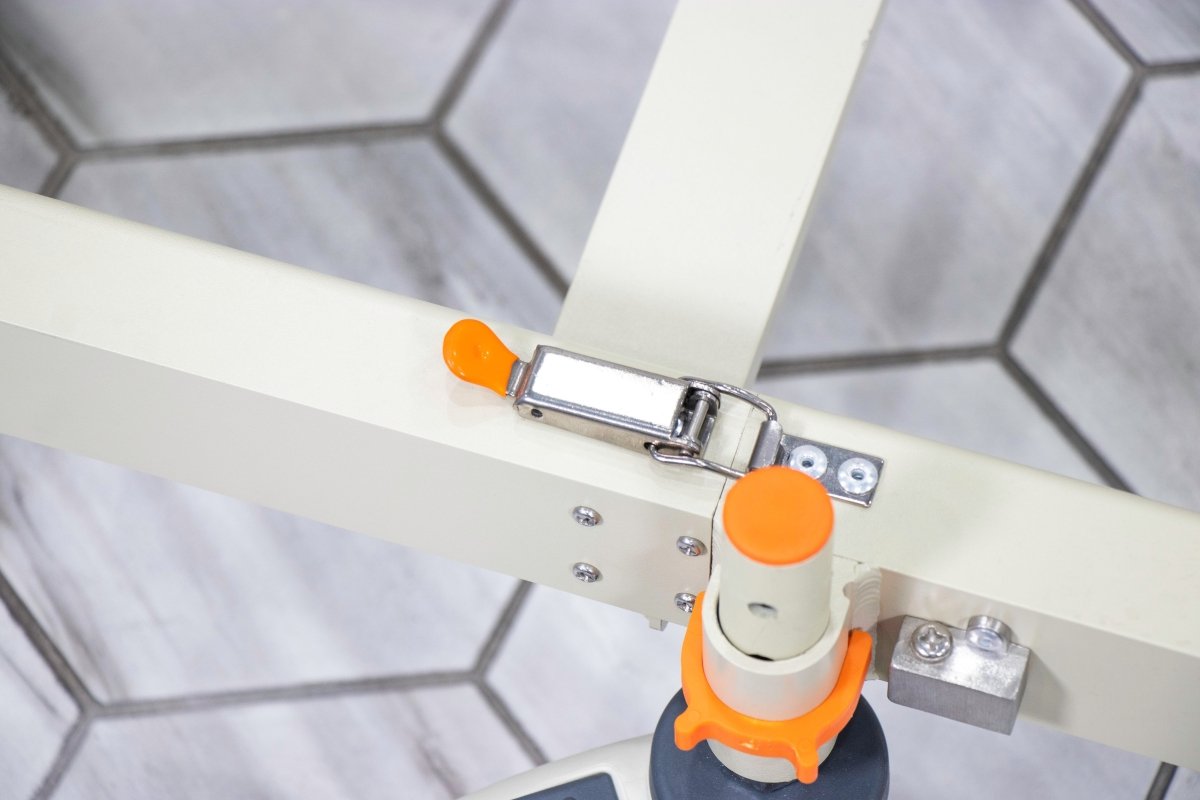 Close-up of orange adjustment knob on shower chair base rail and metal mounting plate