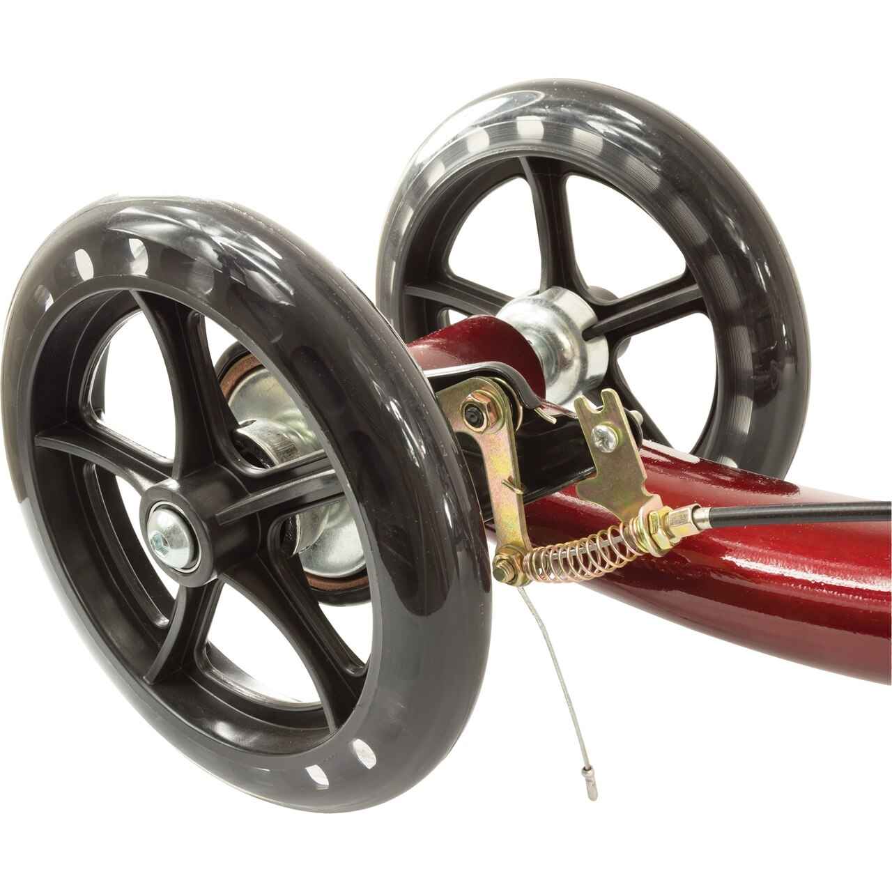 Close-up of wheel assembly on burgundy knee scooter with black tires