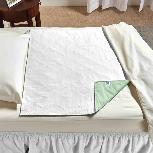 White SleepDri underpad, quilted surface with green-trim corner label