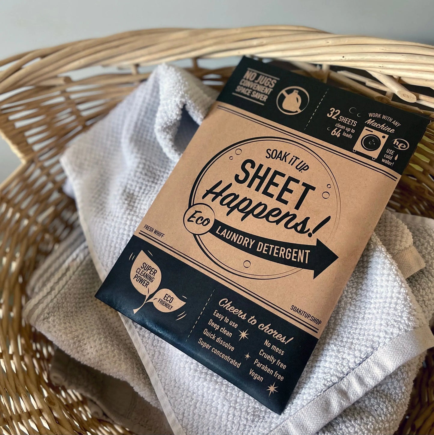 Laundry detergent sheet pouch on folded towels, kraft paper and black label