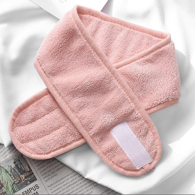 Light pink terry toweling headband with white logo patch, spa facial wear.