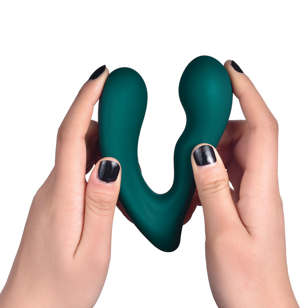 Teal silicone prostate massager held by hands, curved body with rounded tip.