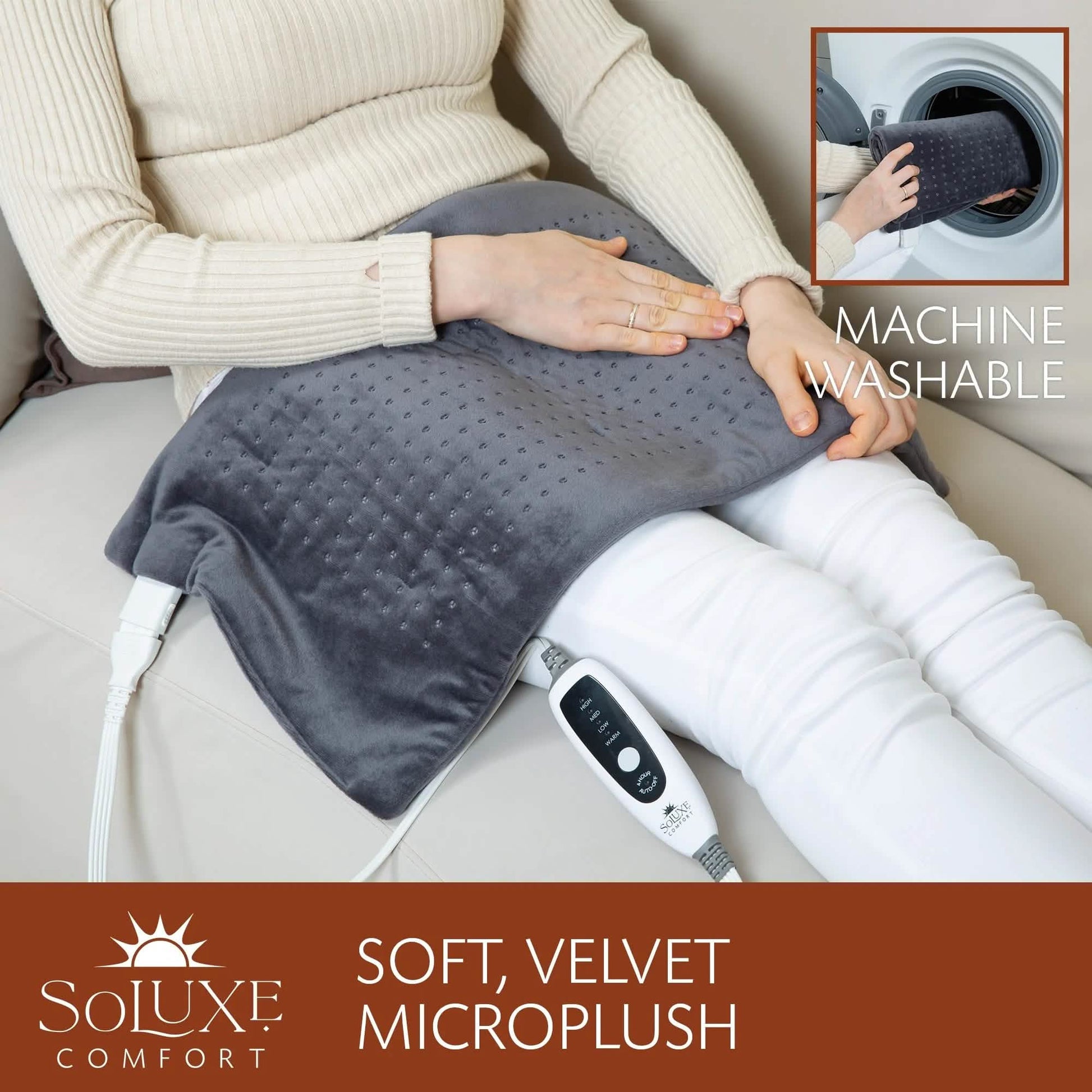 Dark gray heating pad on sofa next to legs with controller cable visible