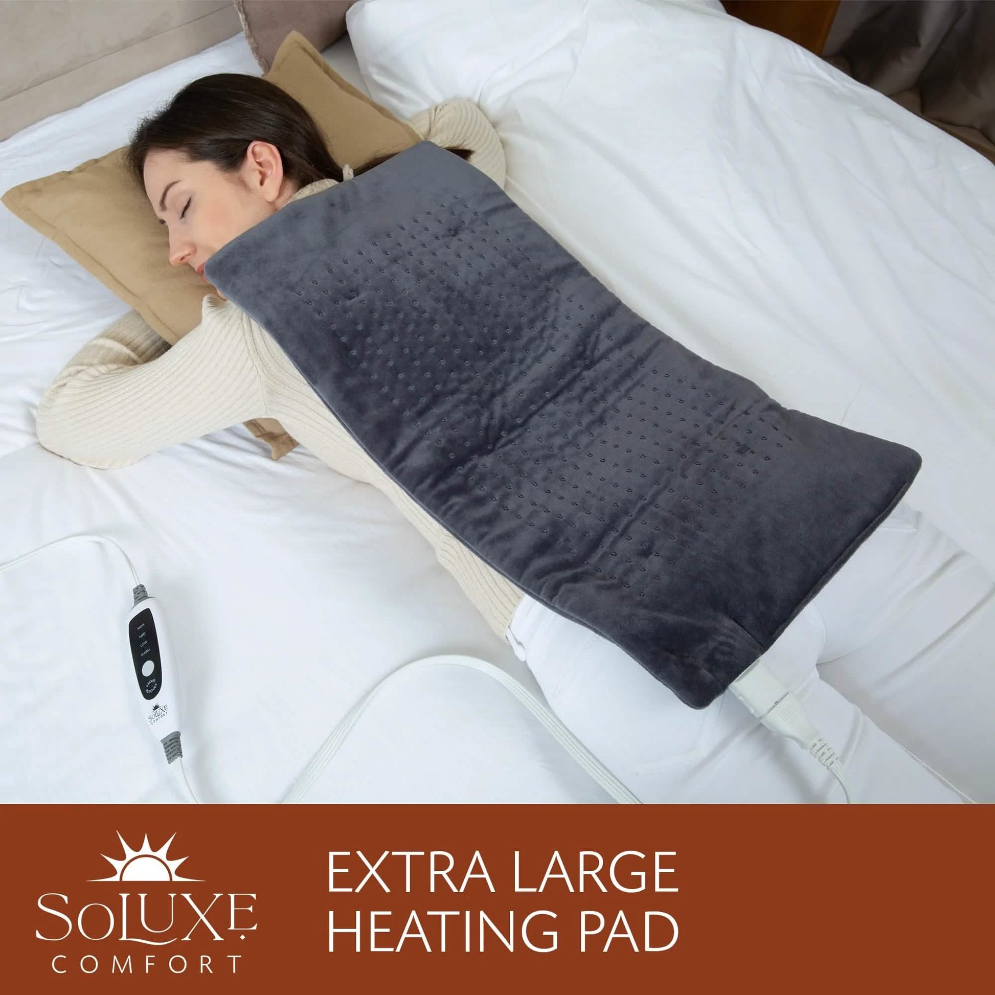 Dark gray heating pad on bed with white cord and controller at left