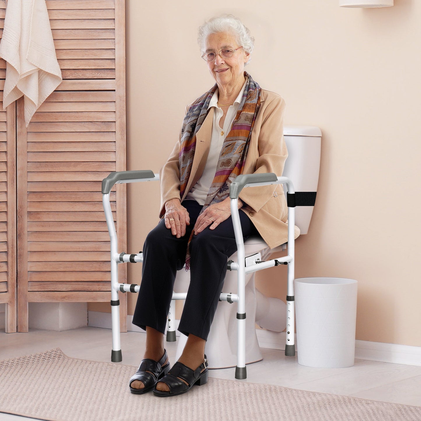 Toilet safety rail with padded armrests shown next to seated person
