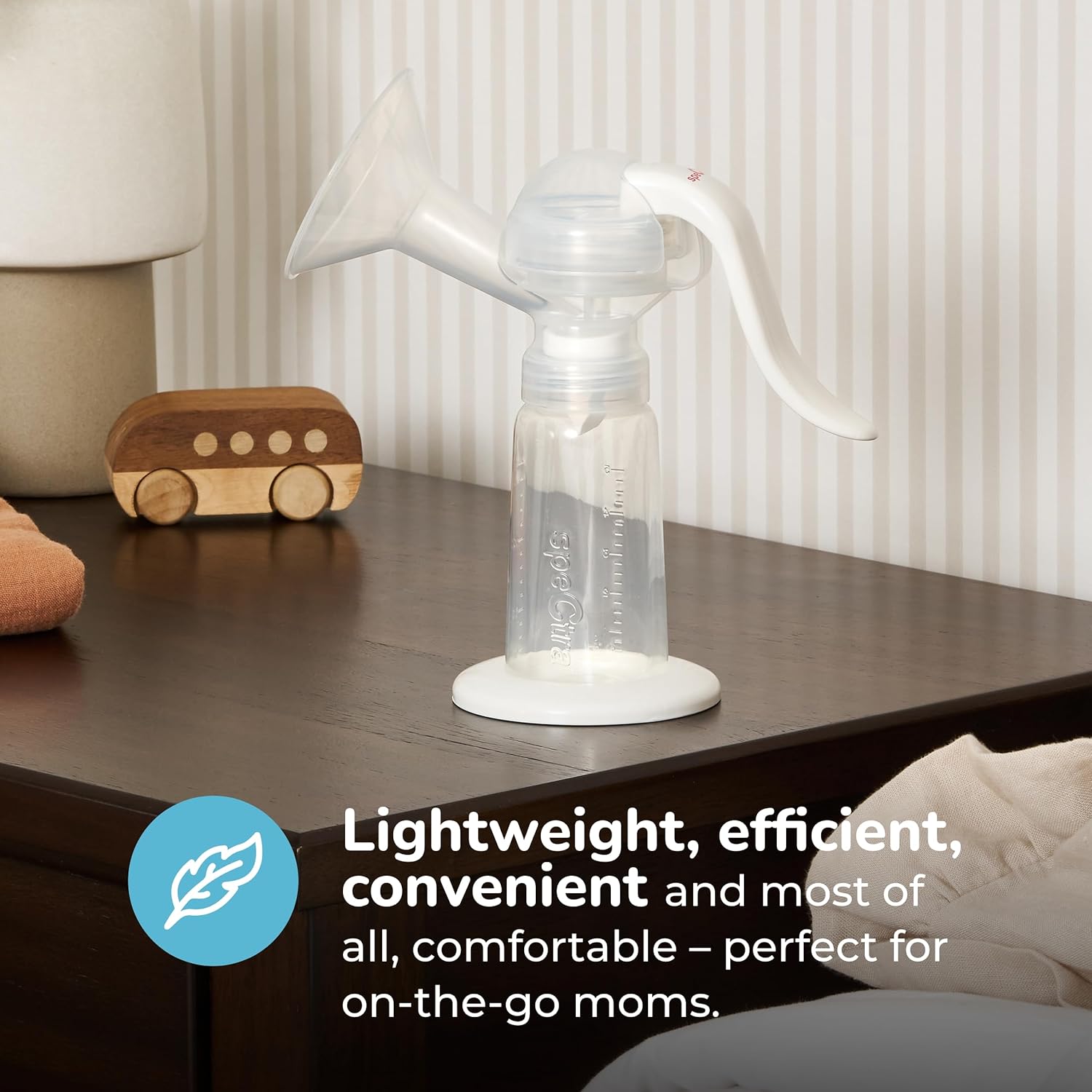 Manual breast pump on base with bottle and connected silicone tubing