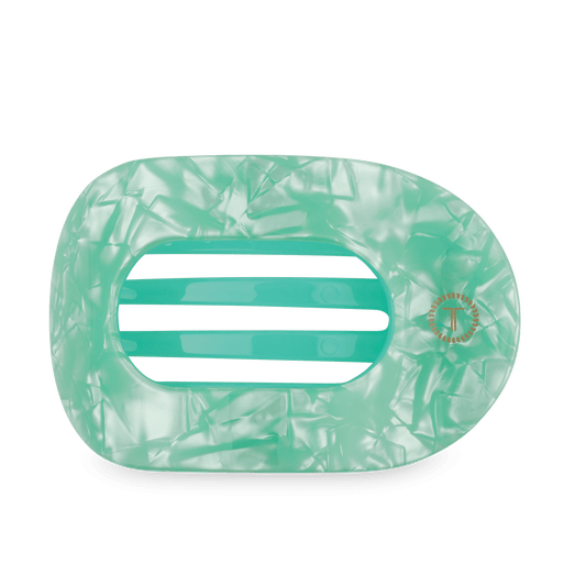 Mint green translucent flat round hair clip with ridged texture and center logo detail