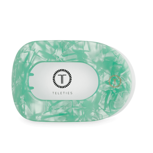 Mint green translucent flat round hair clip, front view with TELETIES logo