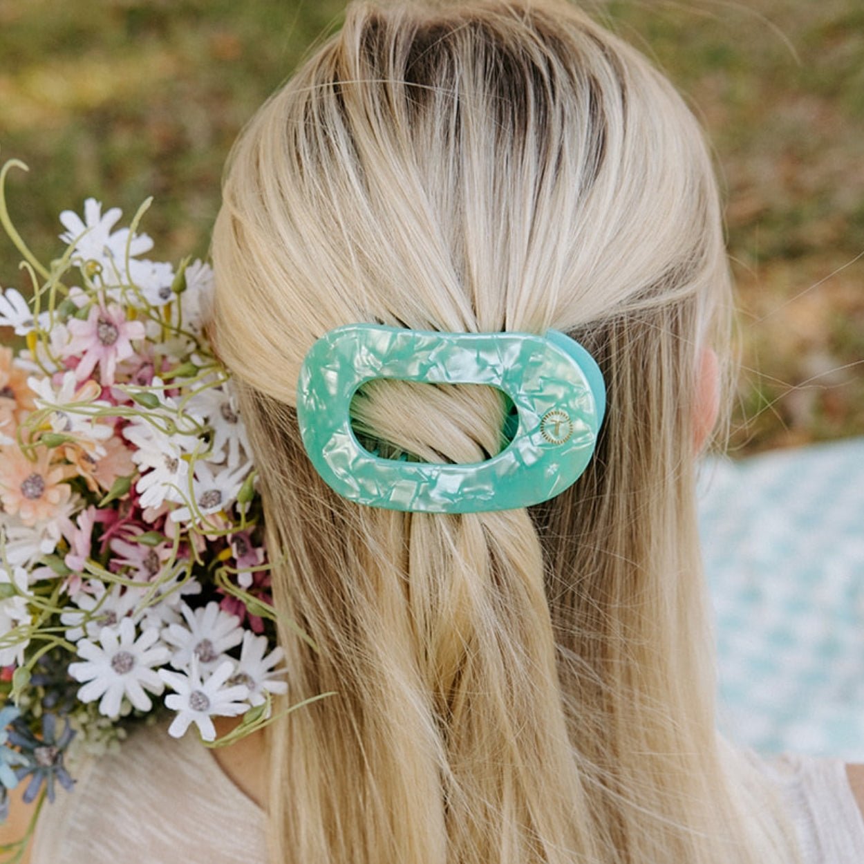 Mint translucent flat hair clip holding blonde hair at the crown