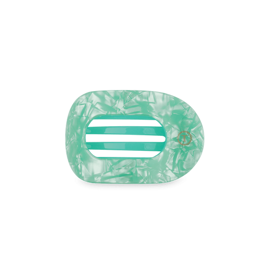Mint green translucent round hair clip with ribbed center and gold emblem detail