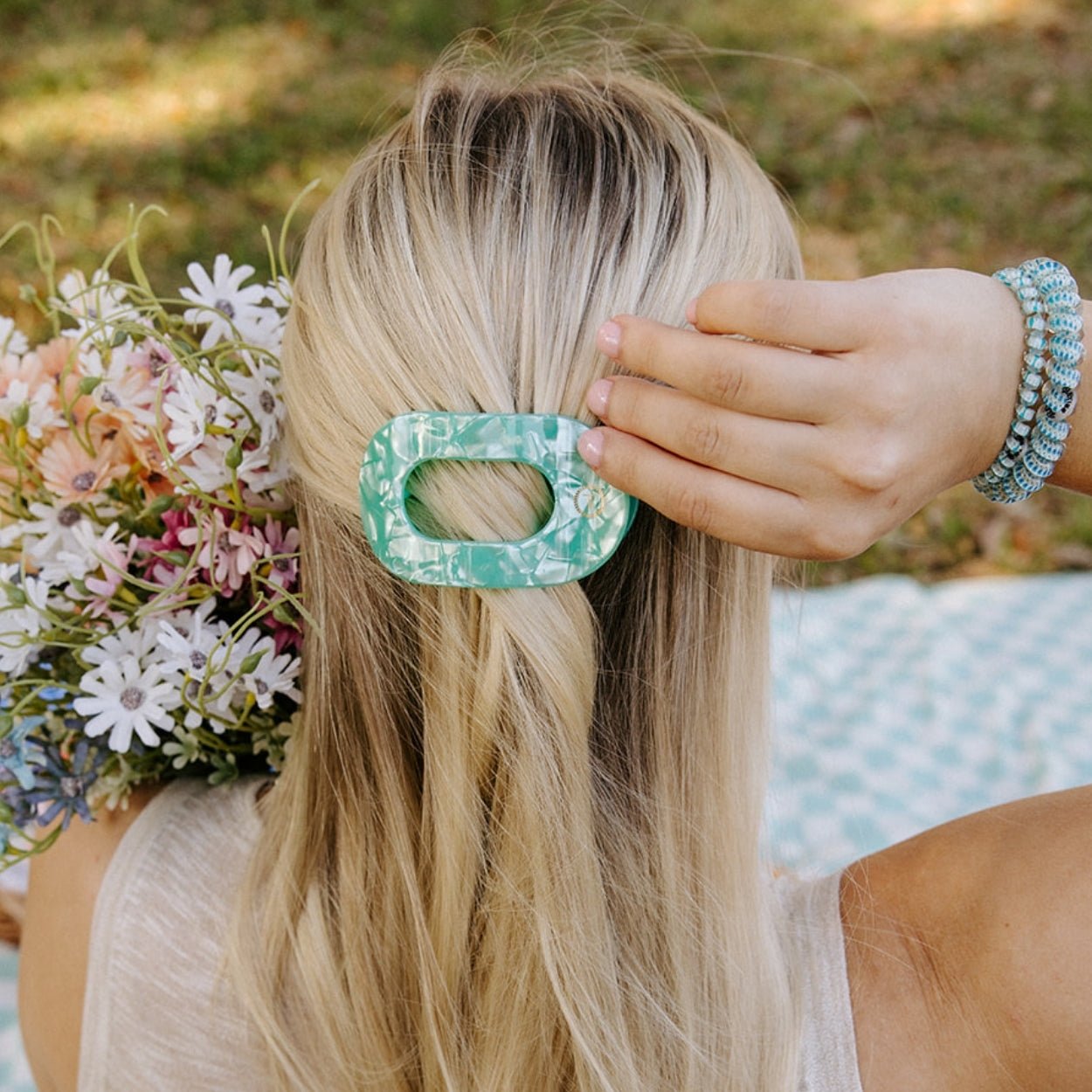 Mint green translucent round hair clip holding blonde hair at the side