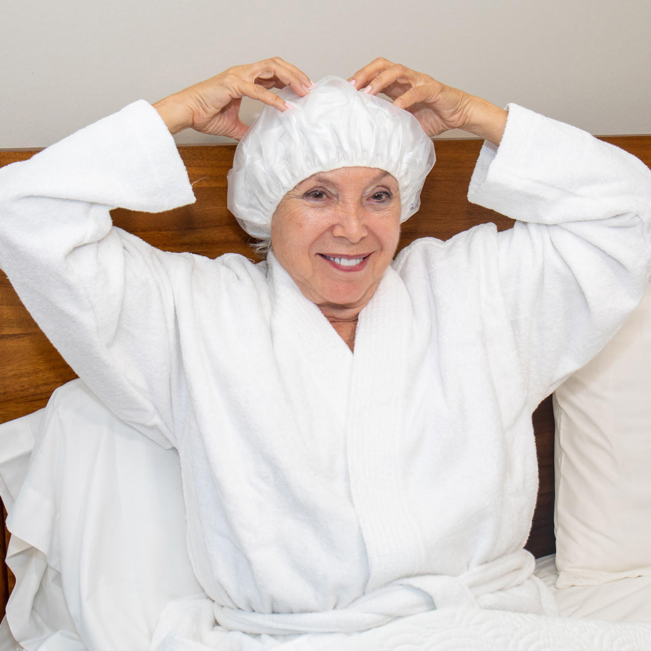 Person wearing a white disposable shampoo cap