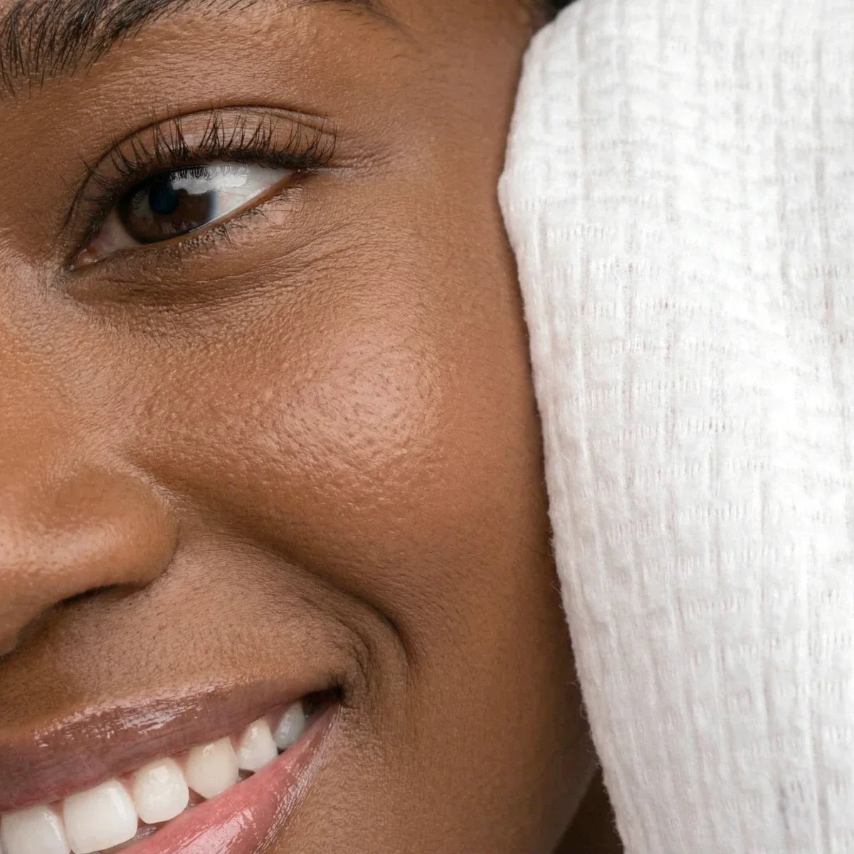 White face towel held against a cheek near the eye