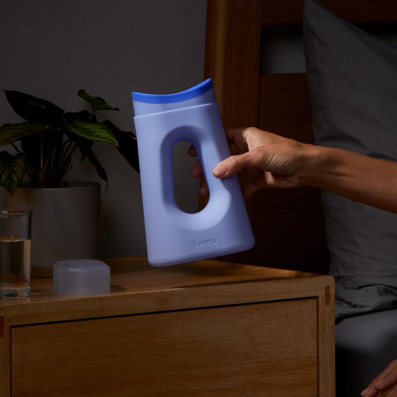 Loona Blue female urinal with closure held in hand, molded plastic with oval outlet