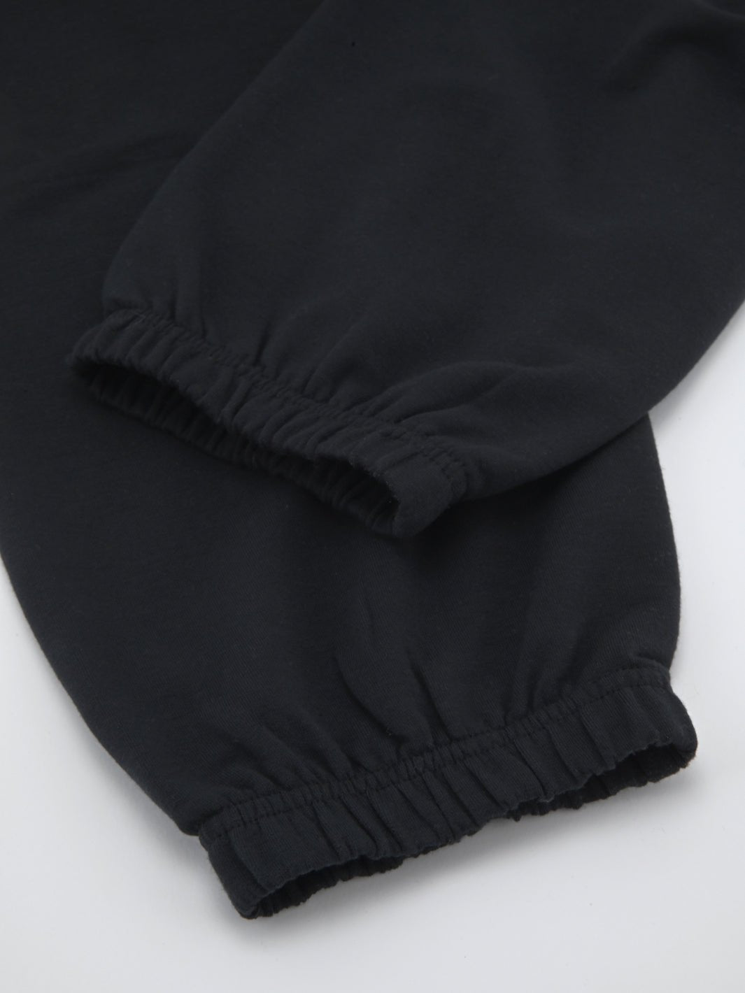 Black lounge sweatpants hem with gathered elastic ankle cuff