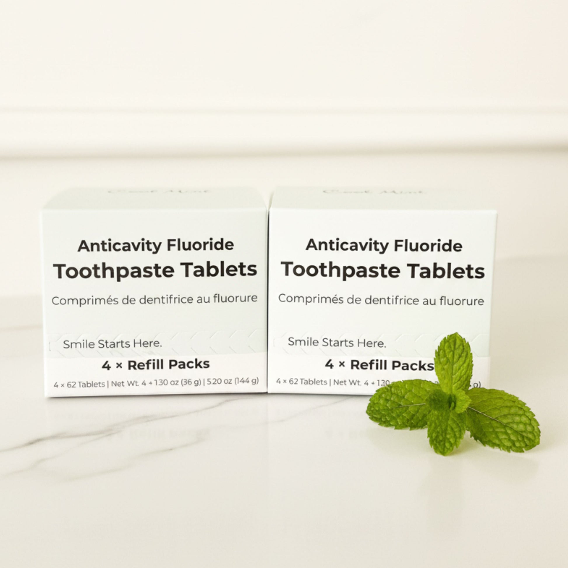 Two refill pack boxes of fluoride toothpaste tablets with mint leaves