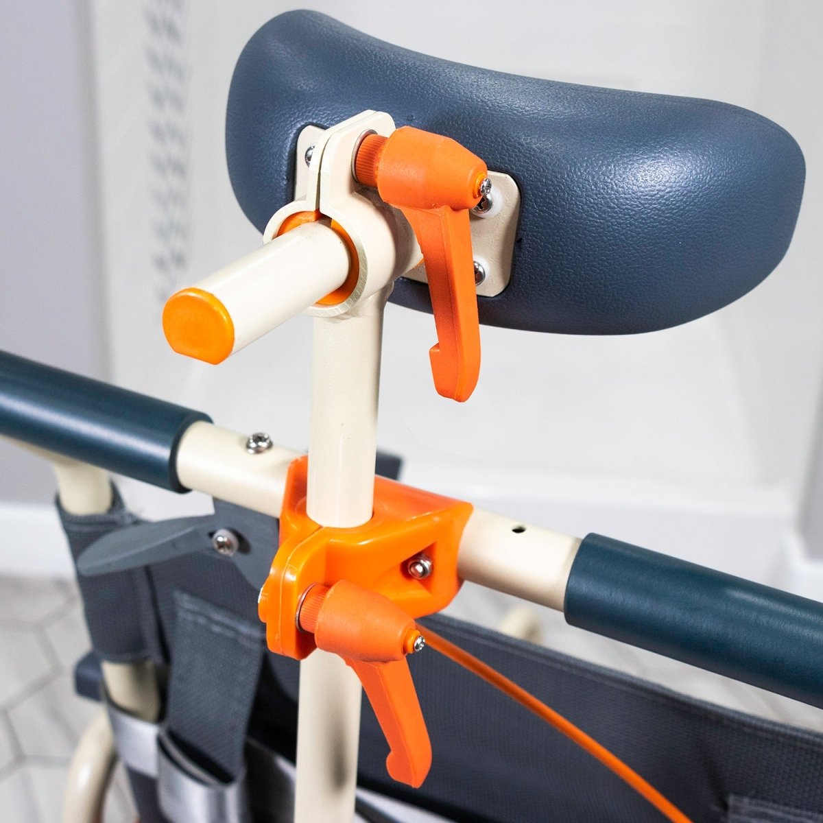 Blue padded shower chair seat with tilt lever and orange adjustment handle