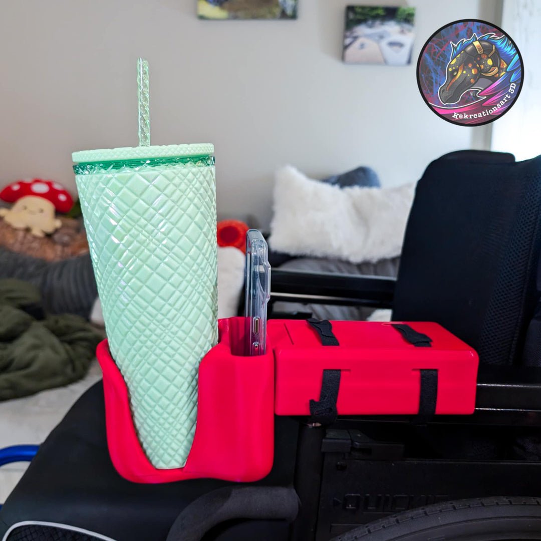 Wheelchair cup and phone holder in bright red, attached to a wheelchair armrest with a large green tumbler and phone inside.